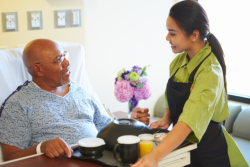 Caregiver serving food to an Elderly